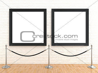 Two blank picture frame on brick wall, with stand rope barriers,