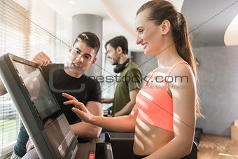 Young woman increasing the speed during a workout session superv
