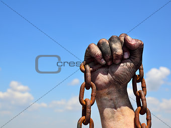 Rusty iron chain in human male right hand 
