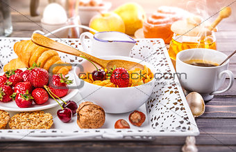 Breakfast with cornflakes berry honey and croissant