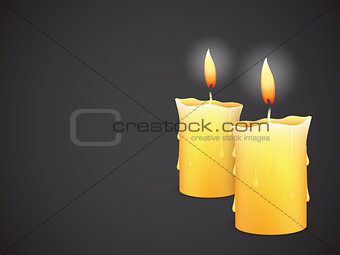 two burning candles on black background