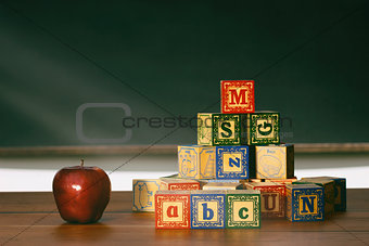 Wooden blocks and apple on desk