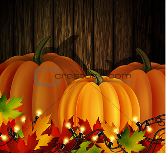 Autumn leaves and pumpkins on wooden texture