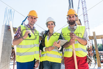 Portrait of confident colleagues posing during work break on construction site