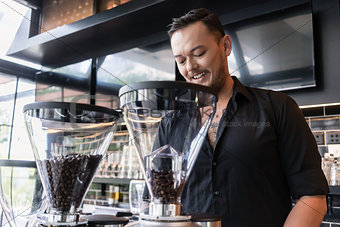 Happy young man preparing espresso while working as barista in a