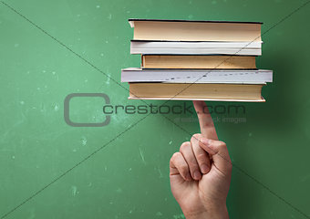 Student holding up books with A Finger