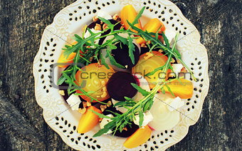 Healthy Beet Salad with red, white, golden beets, arugula, nuts, feta cheese on wooden background