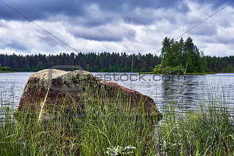 Big stone in the lake at gloomy weather