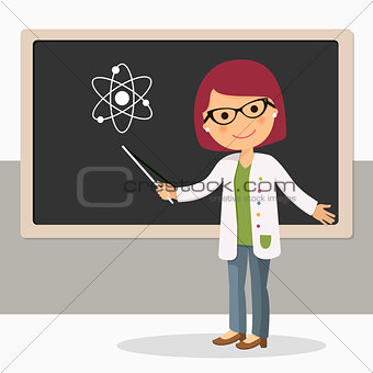 Young female teacher on science lesson at blackboard in classroom