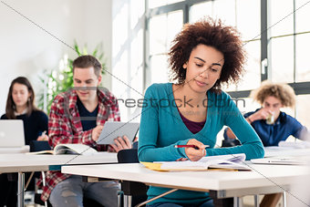 Student concentrating while writing an essay during class in an