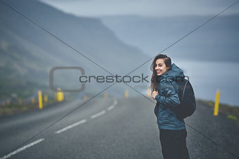 a woman tourist on the empty road on the fjord in Iceland