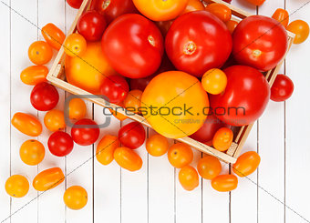 Different tomatoes on white wooden table. Top view