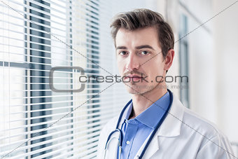 Portrait of a young serious doctor looking at camera with determ