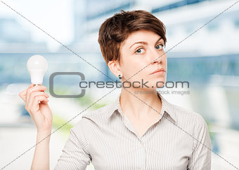 business woman with a light bulb in hand in the office