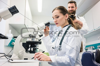 Veterinarian doctors analyzing blood samples of cat in microscop
