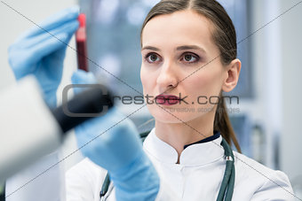 Doctor in medical laboratory looking at blood test