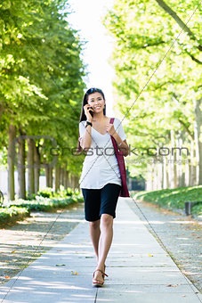 Asian woman talking on mobile phone outdoors
