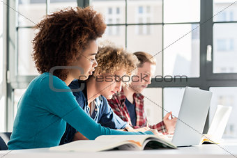 Student smiling while using a laptop for online information or v