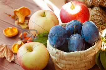 Autumn border made of fruits, vegetables, mushrooms, nuts on a wooden table