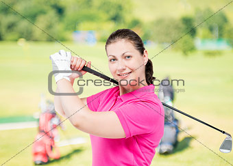 happy girl in a pink shirt on a background of golf courses