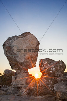 Sun rising between megalithic monument, Montanchez, Spain