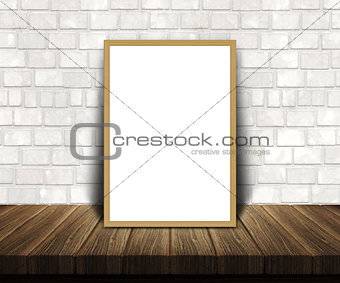 3D blank picture frame on a wooden table leaning against a brick