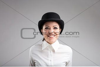 smiling woman in bowler on a gray background