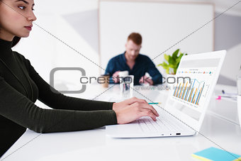 Girl works on a laptop with company statistics. Concept of internet sharing and interconnection