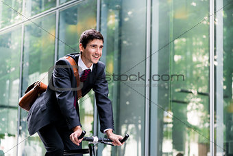 Cheerful young employee riding an utility bicycle in Berlin