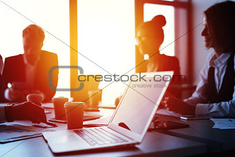 Laptop in an office with businesspeople. Concept of internet sharing and interconnection