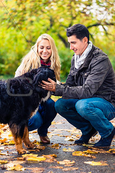 Couple with dog enjoying autumn in nature