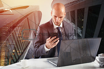 Businessman works with smartphone and laptop