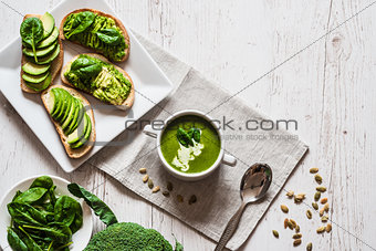 Vegetarian healthy food. Soup and vegan sandwiches. Different sandwiches with avocado. Brunch on white wooden background
