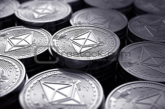 Ethereum coins (ETH) in blurry closeup.