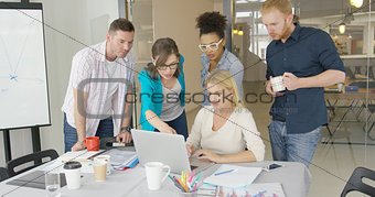 Coworkers with laptop in office