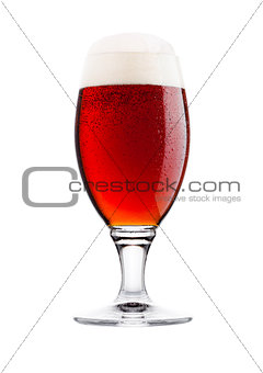 Cold glass of red bitter beer with foam and dew