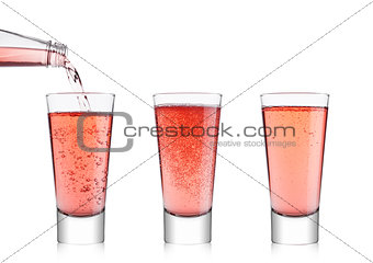 Pouring pink soda lemonade from bottle to glass
