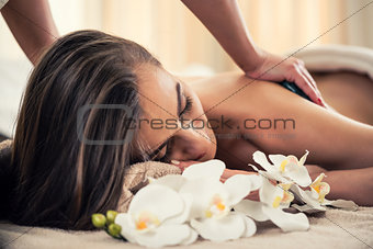 Woman enjoying the therapeutic effects of a traditional hot ston