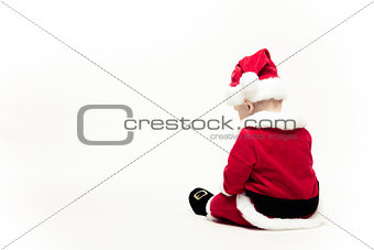Santa Claus baby in red christmas clothes sits with his back isolated on white