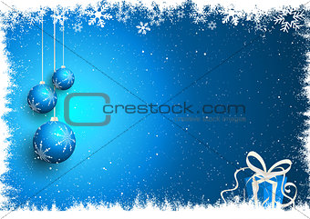 Christmas baubles and gift on snowy background