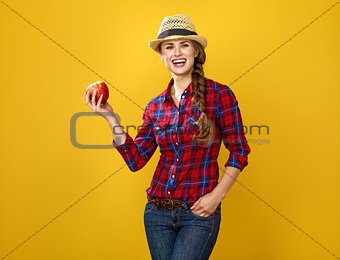 woman grower isolated on yellow background showing an apple