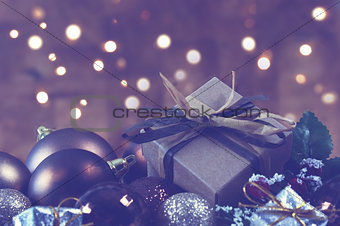 Shabby chic gift nestled in Christmas decorations with bokeh lig