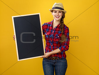 smiling woman grower isolated on yellow showing blank board