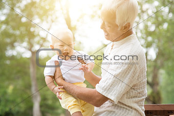 Grandfather with grandson at park.