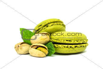two pistachio macarons with nuts isolated on white
