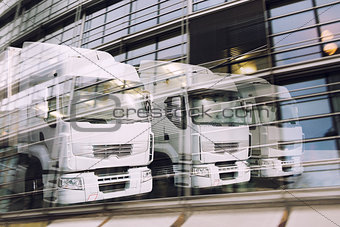 Fast truck reflected on a skyscraper. double exposure