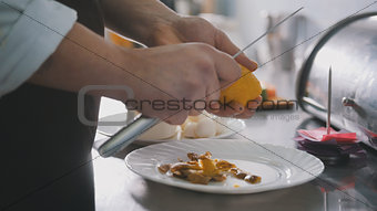 Chef is peeling potatoes for salad in commercial kitchen
