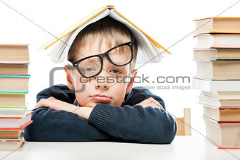 tired schoolboy and piles of books on white background, close-up
