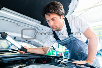 Auto mechanic working in car service workshop