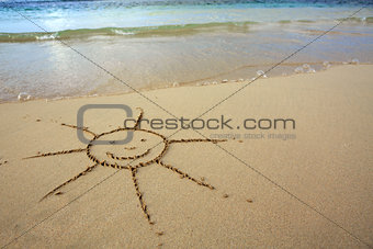 Sun drawing in the sand at the caribbean beach.